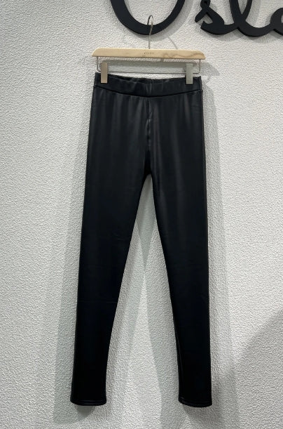 Femme portant un legging noir doublé polaire effet simili cuir, silhouette ajustée, dans un studio neutre