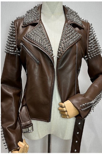 Veste biker en simili cuir marron avec clous métalliques sur les manches et le col, présentée sur mannequin bustier